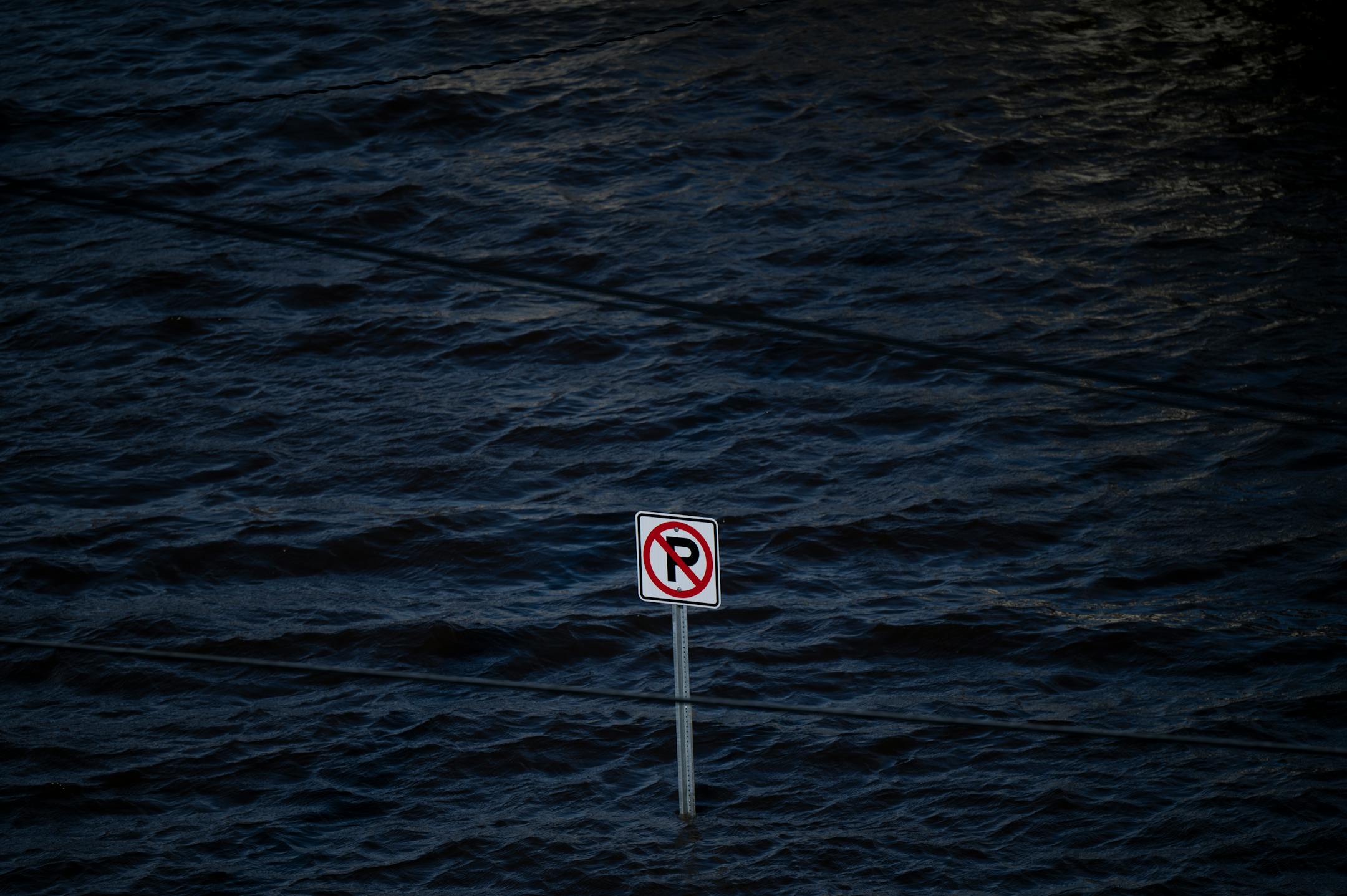 A no parking sign is partially submerged near the Lowell Park Gazebo Monday, April 17, 2023 in Stillwater, Minn.