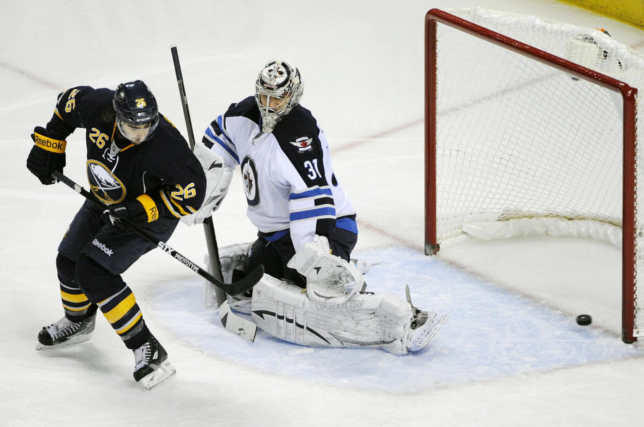 Buffalo Sabres left winger Matt Moulson (26) deflects the puck past Winnipeg Jets goaltender Ondrej Pavelec (31), of Czech Republic, for a goal during the third period of an NHL hockey game in Buffalo, N.Y., Tuesday, Dec. 17, 2013. Buffalo won 4-2. (AP Photo/Gary Wiepert) ORG XMIT: NYGW105