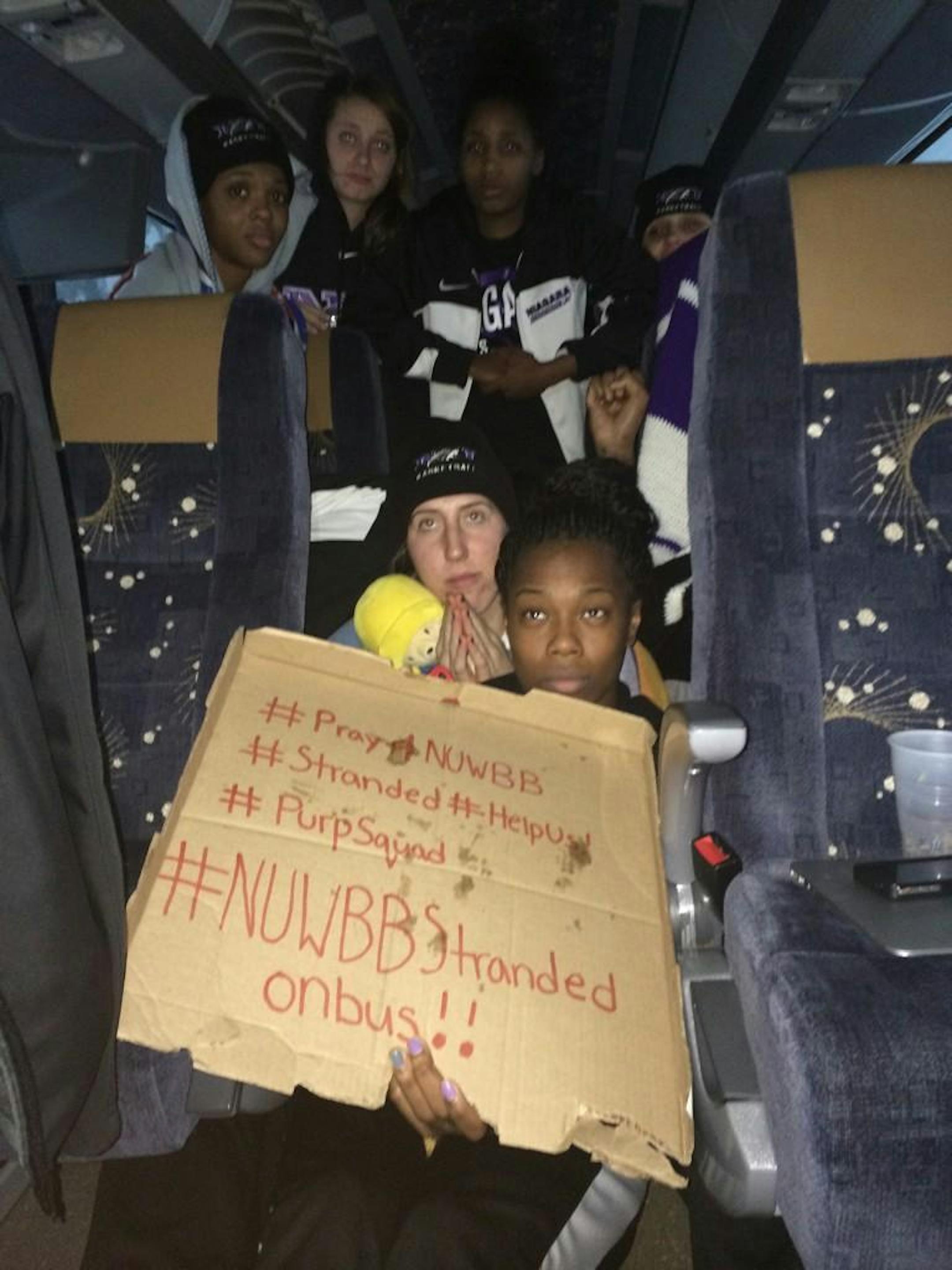 This photo provided by Chelsea Andorka, the Niagara University women�s basketball team spokeswoman, shows the team holding a sign while their bus was snowbound on the New York State Thruway in the middle of a lake-effect storm that has dropped more than 4 feet of snow near Lackawanna, N.Y., Tuesday, Nov. 18, 2014. Andorka says the team's bus was headed back from a loss in Pittsburgh when it came to a halt at 2 a.m. Tuesday about two miles from the Lackawanna exit near Buffalo. About 25 people ar