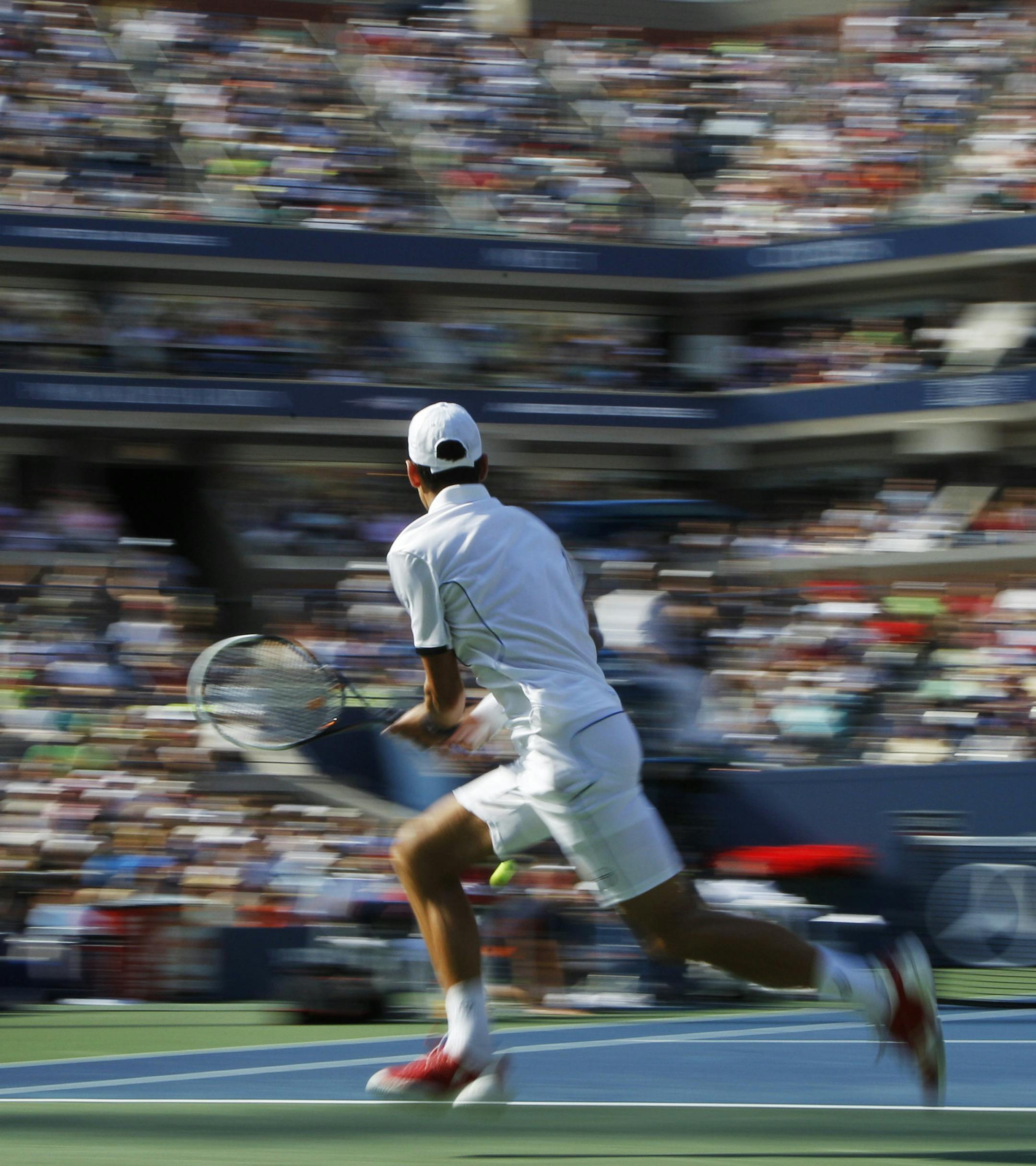 In a photo made using a slow shutter speed to create a blurred effect, Novak Djokovic of Serbia returns a shot to Roger Federer of Switzerland during a semifinal match at the U.S. Open tennis tournament in New York, Saturday, Sept. 10, 2011. (AP Photo/Elise Amendola) ORG XMIT: MIN2013082322462377