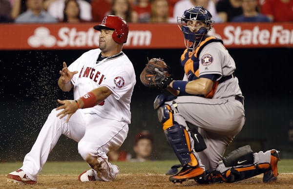 Houston Astros catcher Jason Castro, right, tags out Los Angeles Angels' Albert Pujols, left, trying to advance home from third on a fielder's choice 