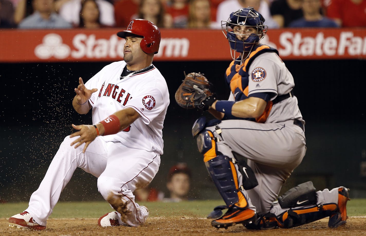 Houston Astros catcher Jason Castro, right, tags out Los Angeles Angels' Albert Pujols, left, trying to advance home from third on a fielder's choice during the sixth inning of a baseball game in Anaheim, Calif., Monday, June 27, 2016. (AP Photo/Alex Gallardo) ORG XMIT: OTKAG