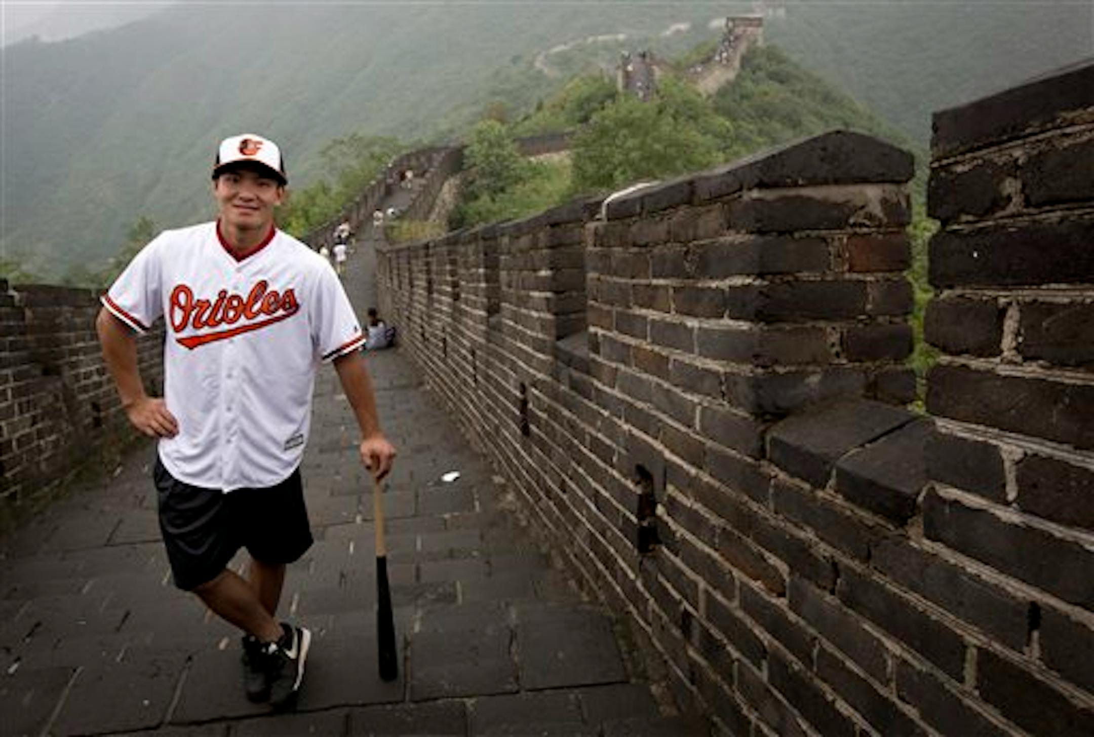 Chinese baseball player Xu Guiyan wearing the Baltimore Orioles team jersey poses at the Mutianyu section of the Great Wall of China in Beijing Thursday, July 23, 2015. The hardest part for Xu Guiyan about signing with the Baltimore Orioles was keeping it a secret. The 19-year-old Xu this week became the first player from one of the MLB's three development centers in China to sign with a major league club. (AP Photo/Andy Wong)