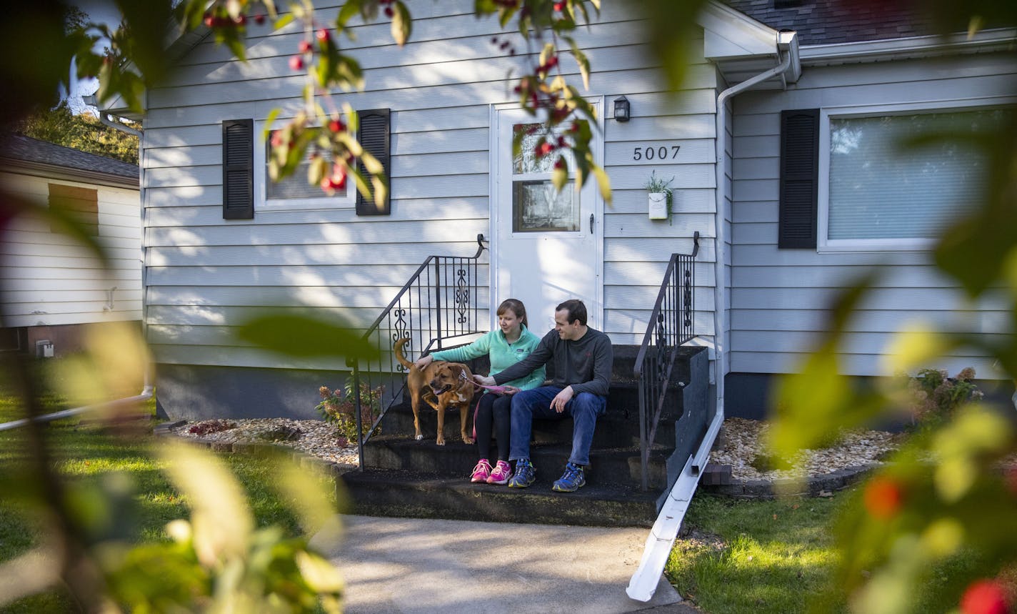 Mary Krull and Chris Aepelbache pet Mary's dog, Laila, on their front porch on Monday October, 7th after walking through the Lester Park trail.