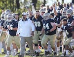 As the clock expires Bethel University players and coaches celebrate their 35-24 win over the Univeristy of St. Thomas at Bethel campus stadium Saturd