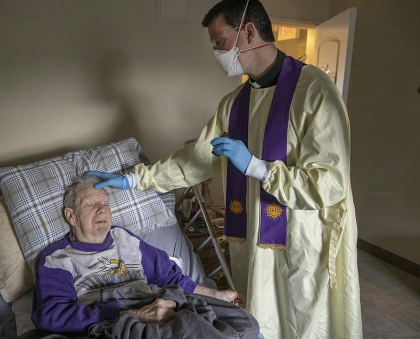 The Rev. Andrew Jaspers gave last rites to 85-year-old COVID-19 patient Chuck Schuh on December 5, 2020. Schuh's family gave permission for this photograph. "Chuck, you are good to go," Jaspers said. (Elizabeth Flores/Minneapolis Star Tribune/TNS) ORG XMIT: 1855657