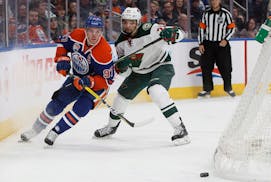 Minnesota Wild's Matt Dumba (24) defends against Edmonton Oilers' Connor McDavid (97) during the second period of an NHL hockey game in Edmonton, Albe