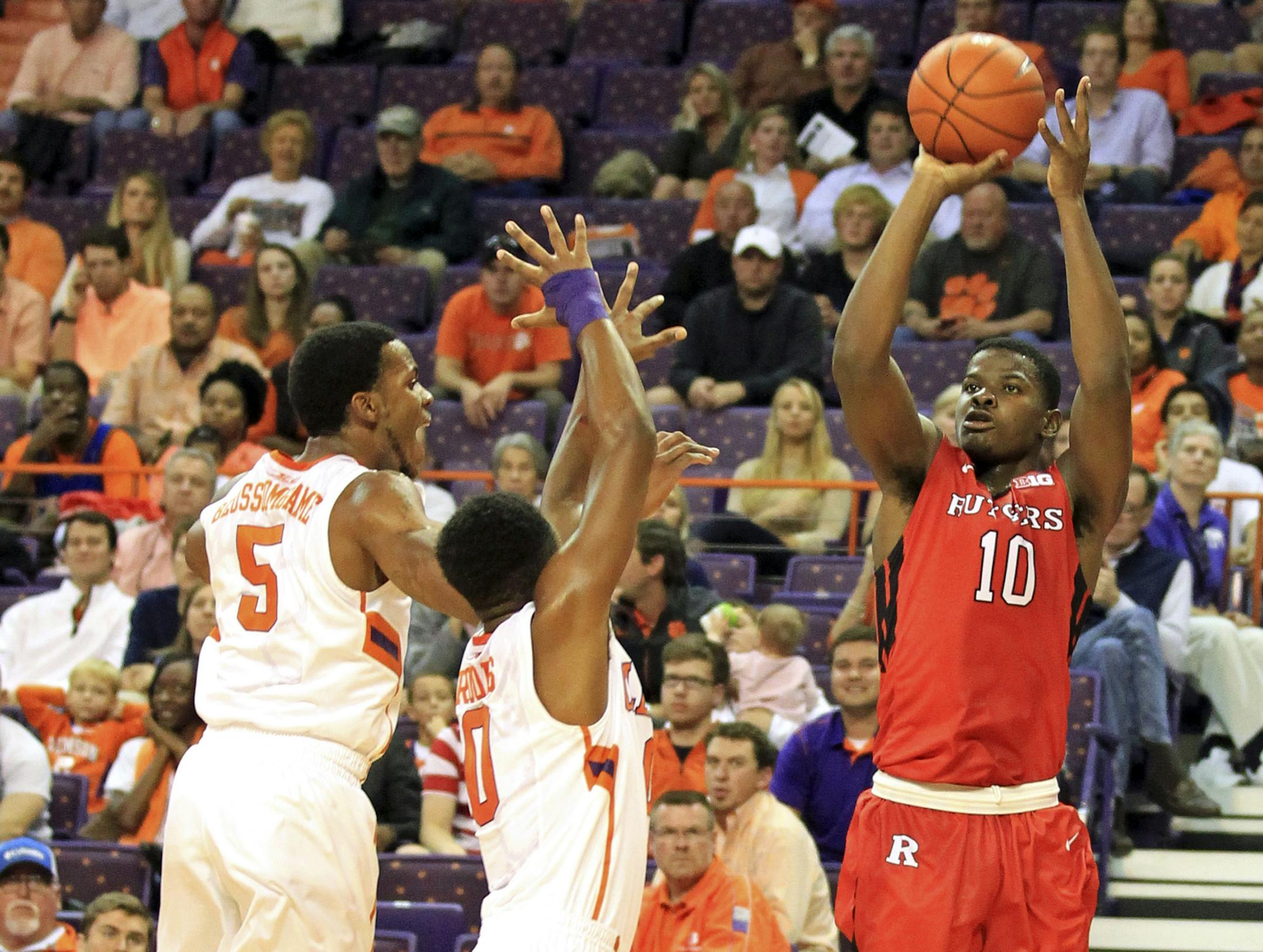 Rutgers' Junior Etou, right, shoots over Clemson's Jaron Blossomgame, left, and Patrick Rooks during the first half of an NCAA college basketball game at Littlejohn Coliseum in Clemson, S.C., Monday, Dec. 1, 2014. (AP Photo/The Independent-Mail, Mark Crammer)