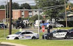 Police and RCMP officers survey the area of a shooting in Fredericton, New Brunswick, Canada on Friday, Aug. 10, 2018. Fredericton police say two offi