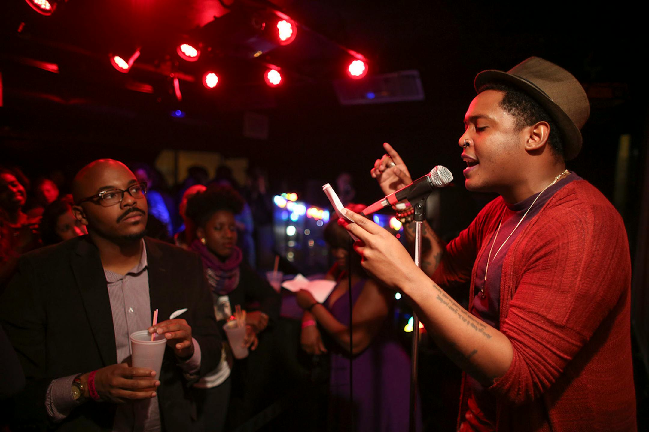 Poet Nate Marshall, left, listened to the reading of a Prince-inspired poem by Danez Smith during The Prince Purple Poetry Party Wednesday night at First Ave. ] JEFF WHEELER • jeff.wheeler@startribune.com One of the off-site events at the start of the AWP Conference & Bookfair was The Prince Purple Poetry Party Wednesday night, April 8, 2015 in The Record Room at First Ave. in Minneapolis. More than a dozen poets read poems they wrote that were inspired by the music of Prince.