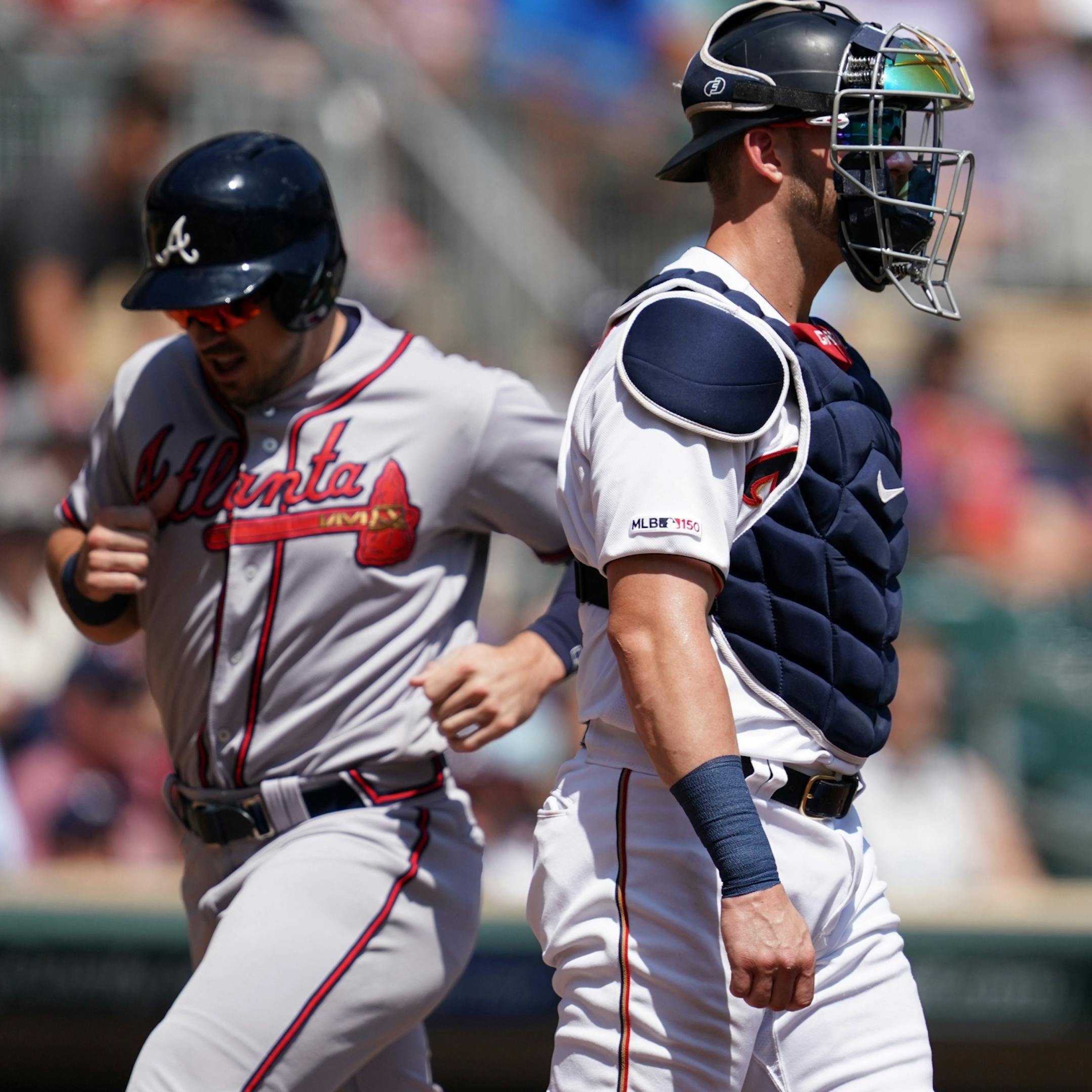 Minnesota Twins catcher Mitch Garver (18) stood by as Atlanta Braves left fielder Adam Duvall (23) passed over home, scoring on a double hit by Atlanta Braves shortstop Charlie Culberson (8) in the first inning.
