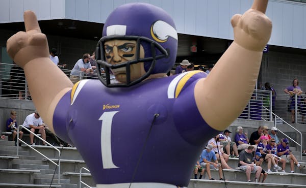 Before a joint practice between the Minnesota Vikings and the Jacksonville Jaguars, fans sit in the stands by a giant inflatable Viking Thursday, Aug.
