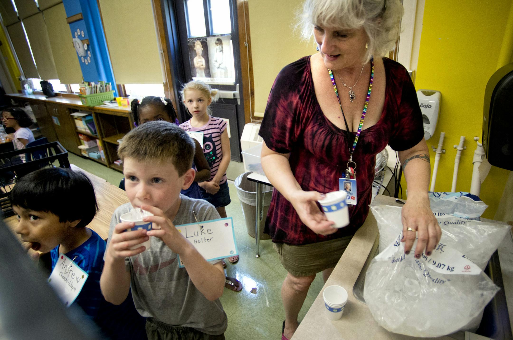 First grade teacher Tani Langree distributed cups of ice to her students in her un air conditioned classroom where temperatures were in the mid 80s. Hiawatha Elementary School in Minneapolis is without air conditioning and struggled through the first day of classes with lots of bottled water, donated ice and popsicles, Monday, August 26, 2013 ] GLEN STUBBE * gstubbe@startribune.com
