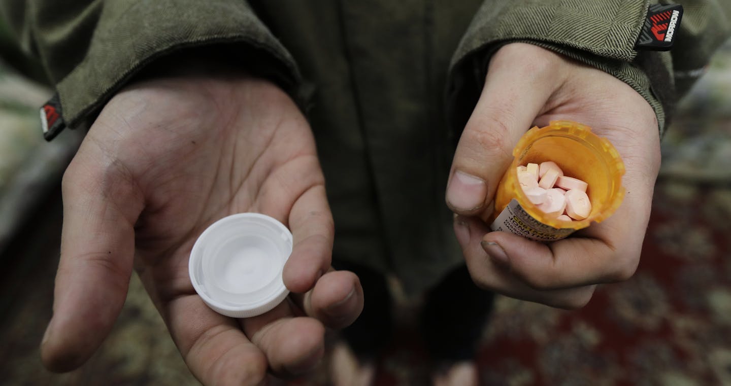 In this Nov. 14, 2019 photo, Jon Combes holds his bottle of buprenorphine, a medicine that prevents withdrawal sickness in people trying to stop using opiates, as he prepares to take a dose in a clinic in Olympia, Wash. The clinic is working to spread a philosophy called "medication first," which scraps requirements for counseling, abstinence or even a commitment to recovery in the battle against addictions to heroin and other opioids. (AP Photo/Ted S. Warren)