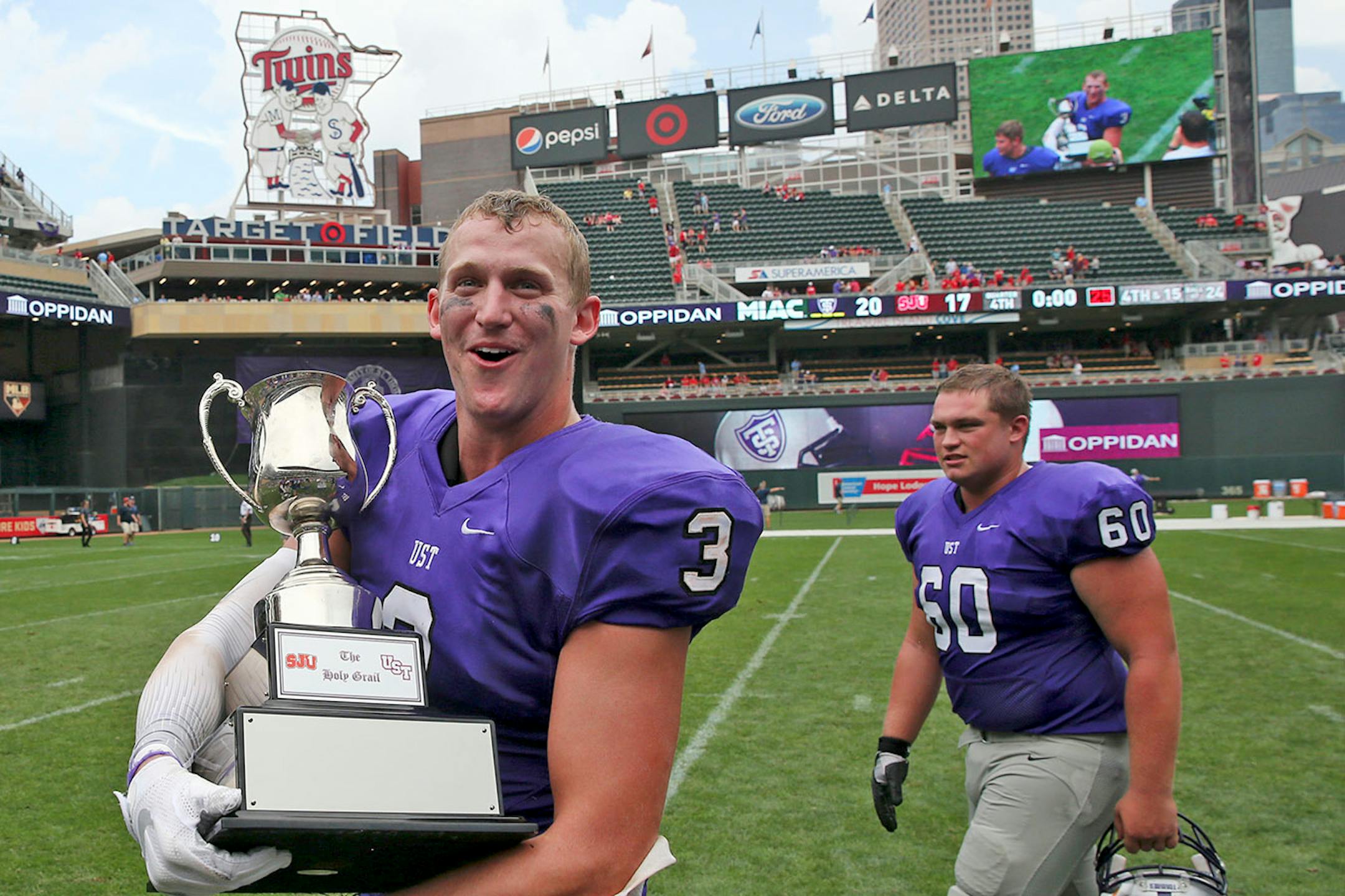 University of St. Thomas wide receiver Tanner Vik (3) walked on the field with the Holy Grail trophy after the win.