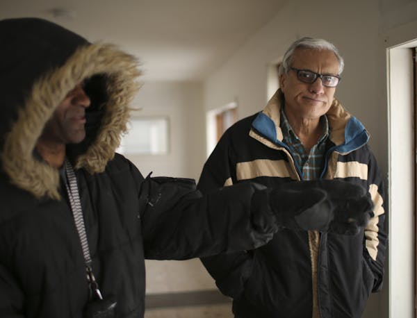Mahmoud Khan with a member of his maintenance crew, Melvin Snoddy, left, in one of his former rental properties in north Minneapolis Monday afternoon.