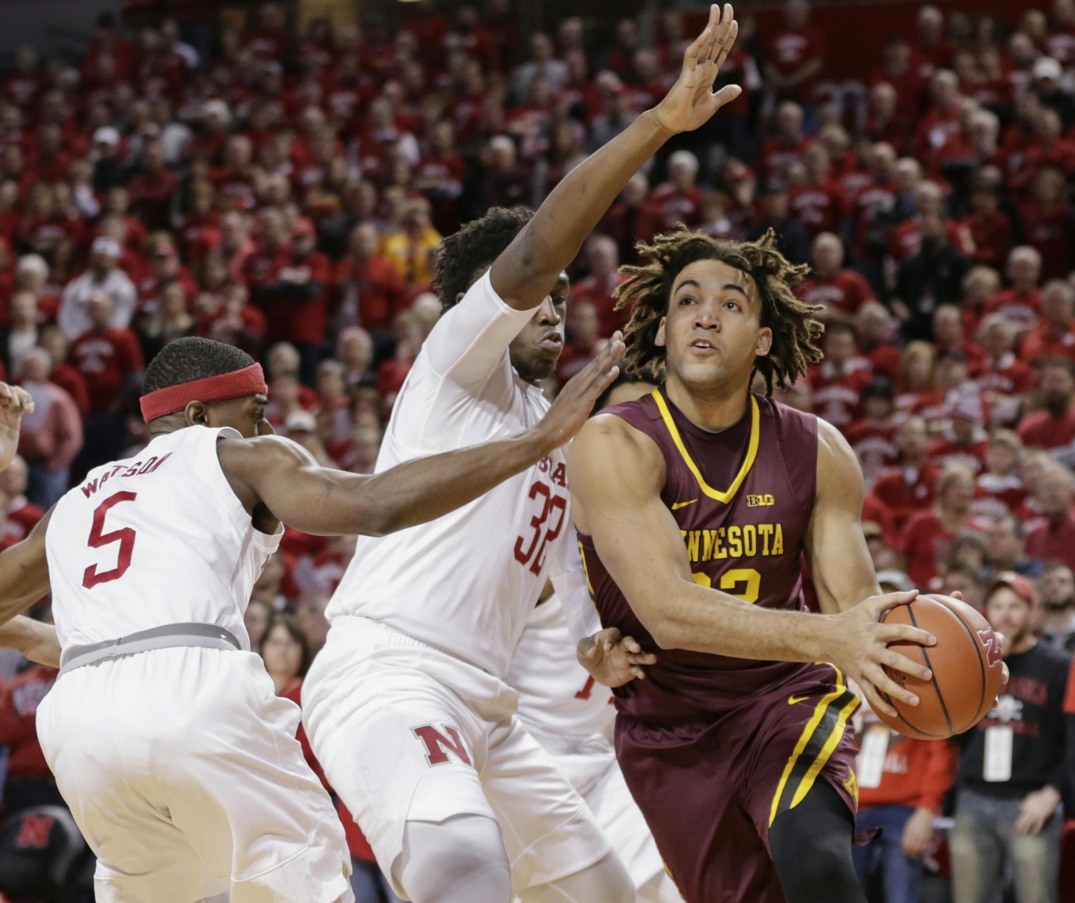 Minnesota's Reggie Lynch, right, drives to the basket against Nebraska's Glynn Watson Jr. (5) and Jordy Tshimanga (32) during the first half of an NCAA college basketball game in Lincoln, Neb., Tuesday, Dec. 5, 2017.