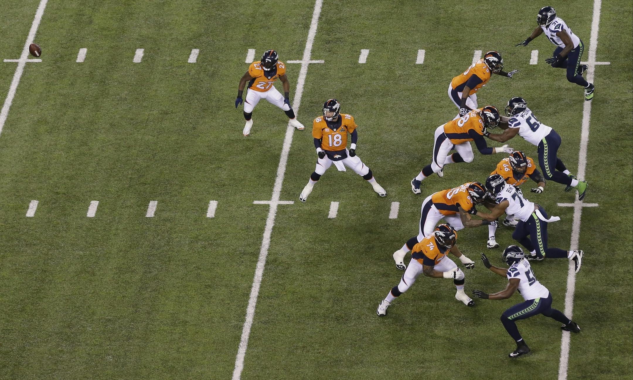 Denver Broncos' Peyton Manning (18) watches the ball go over his head after a bad snap for a safety during the first half of the NFL Super Bowl XLVIII football game against the Seattle Seahawks Sunday, Feb. 2, 2014, in East Rutherford, N.J. (AP Photo/Mel Evans)
