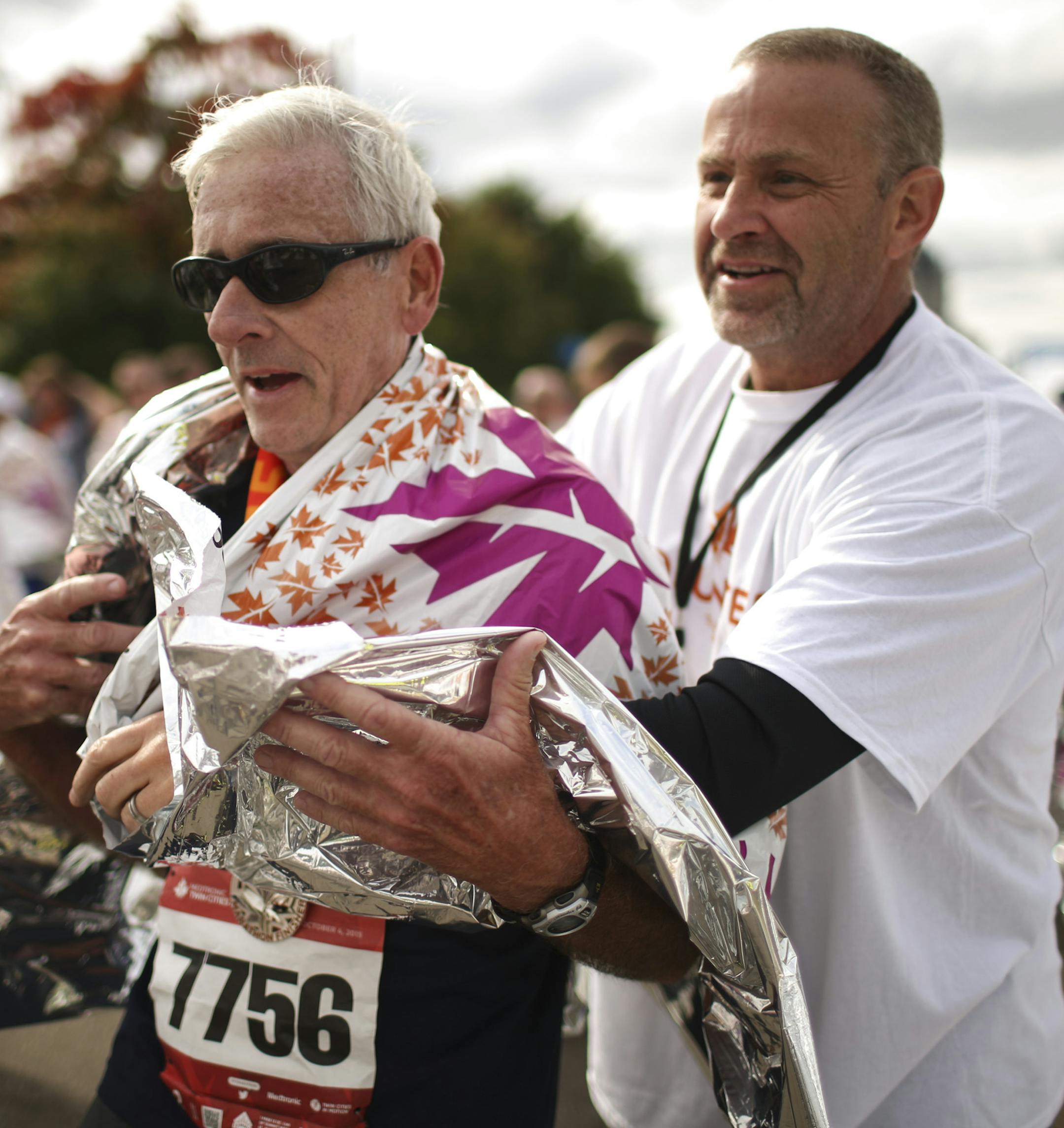 A volunteer covered David Deem of MacHesney Park, IL with a space blanket after he finished Sunday. ] JEFF WHEELER • jeff.wheeler@startribune.com More than 11,000 runners started the Twin Cities Marathon Sunday morning, October 4, 2015 in Minneapolis.