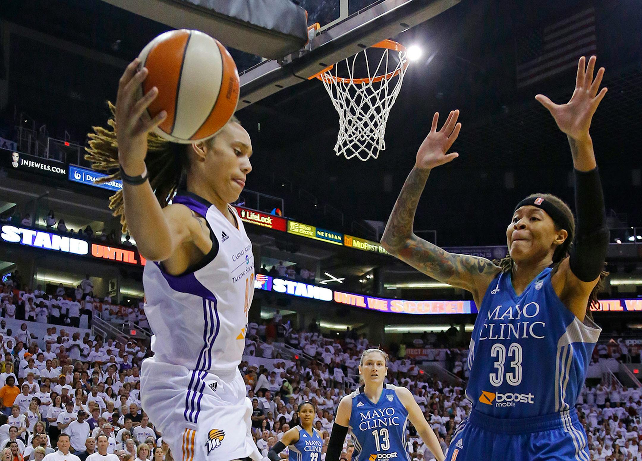 Phoenix Mercury center Brittney Griner (42) tries to keep the ball in bounds against Minnesota Lynx guard Seimone Augustus (33) during the first quarter of Game 1 of the WNBA Western Conference finals Friday, Aug. 29, 2014 in Phoenix, Ariz.