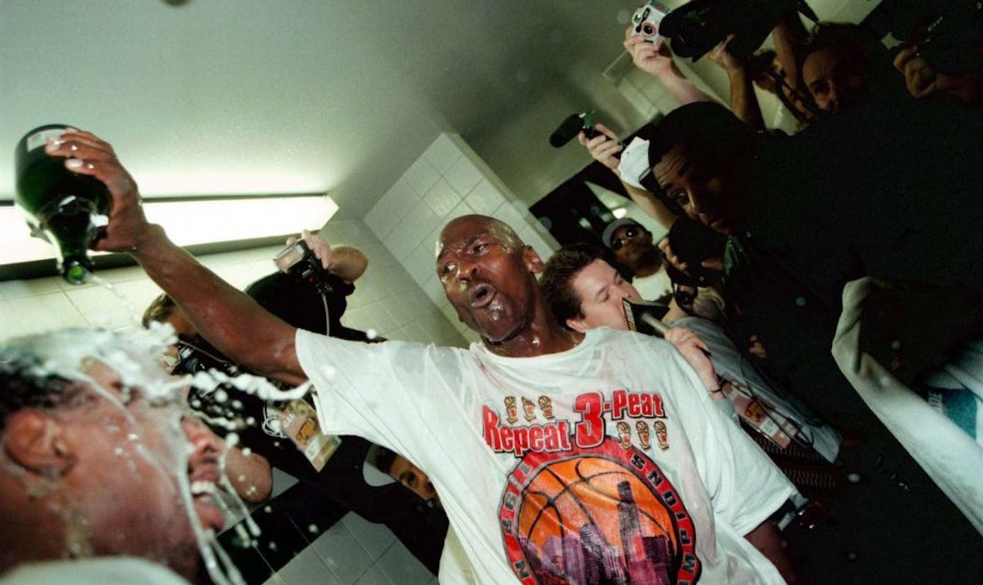 Michael Jordan pours bubbly on Dennis Rodman inside the locker room after winning the NBA title on June 14, 1998.