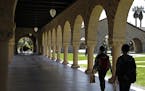 FILE - In this March 14, 2019, file photo, people walk on the Stanford University campus in Santa Clara, Calif. Financial aid award letters are known 