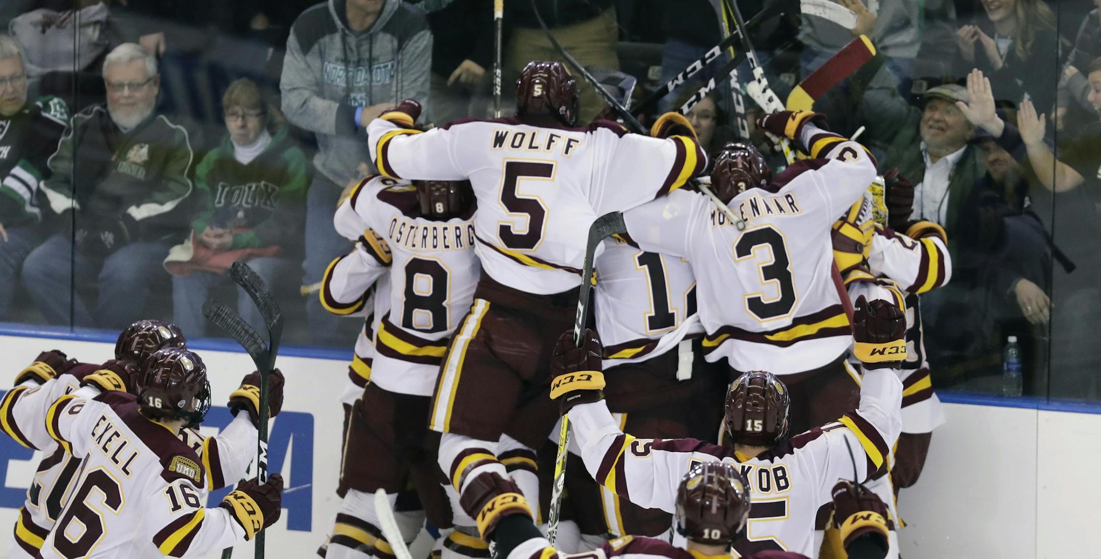 Minnesota-Duluth players surround Adam Johnson after his goal during overtime of the NCAA West Regional college hockey final against Boston University, Saturday, March 25, 2017, in Fargo, N.D. Minnesota-Duluth won 3-2. (AP Photo/Carlos Osorio)