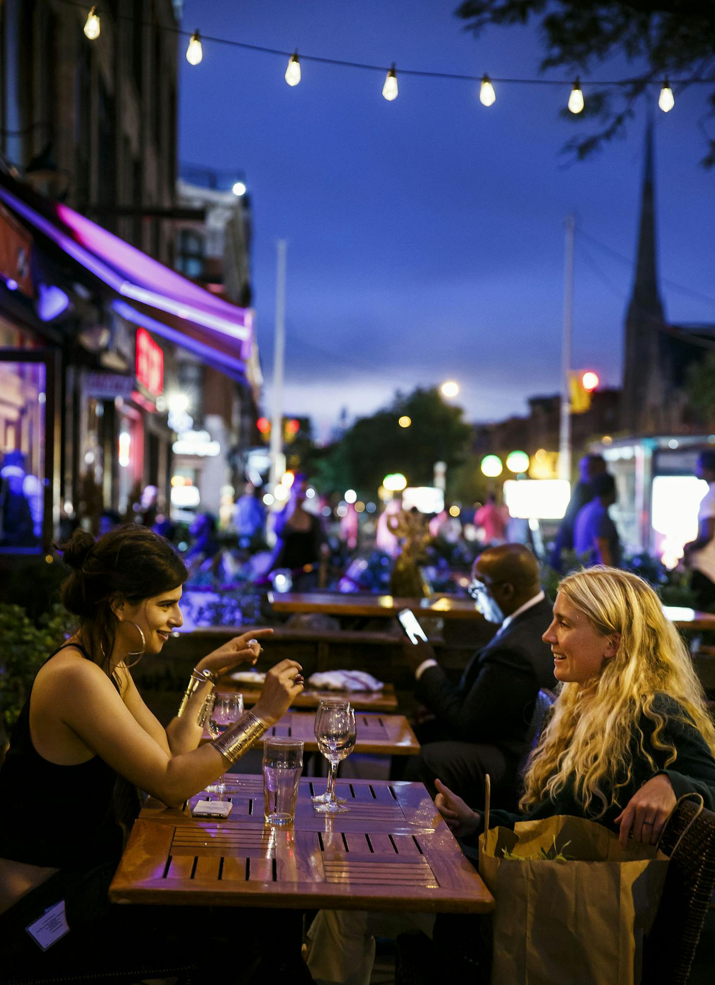 Liana Satenstein, left, and Emily Rosser, right, enjoy drinks on a breezy and cool evening in the outside patio at Red Rooster on July 31, 2016 in New York. (Marcus YamLos Angeles Times/TNS)