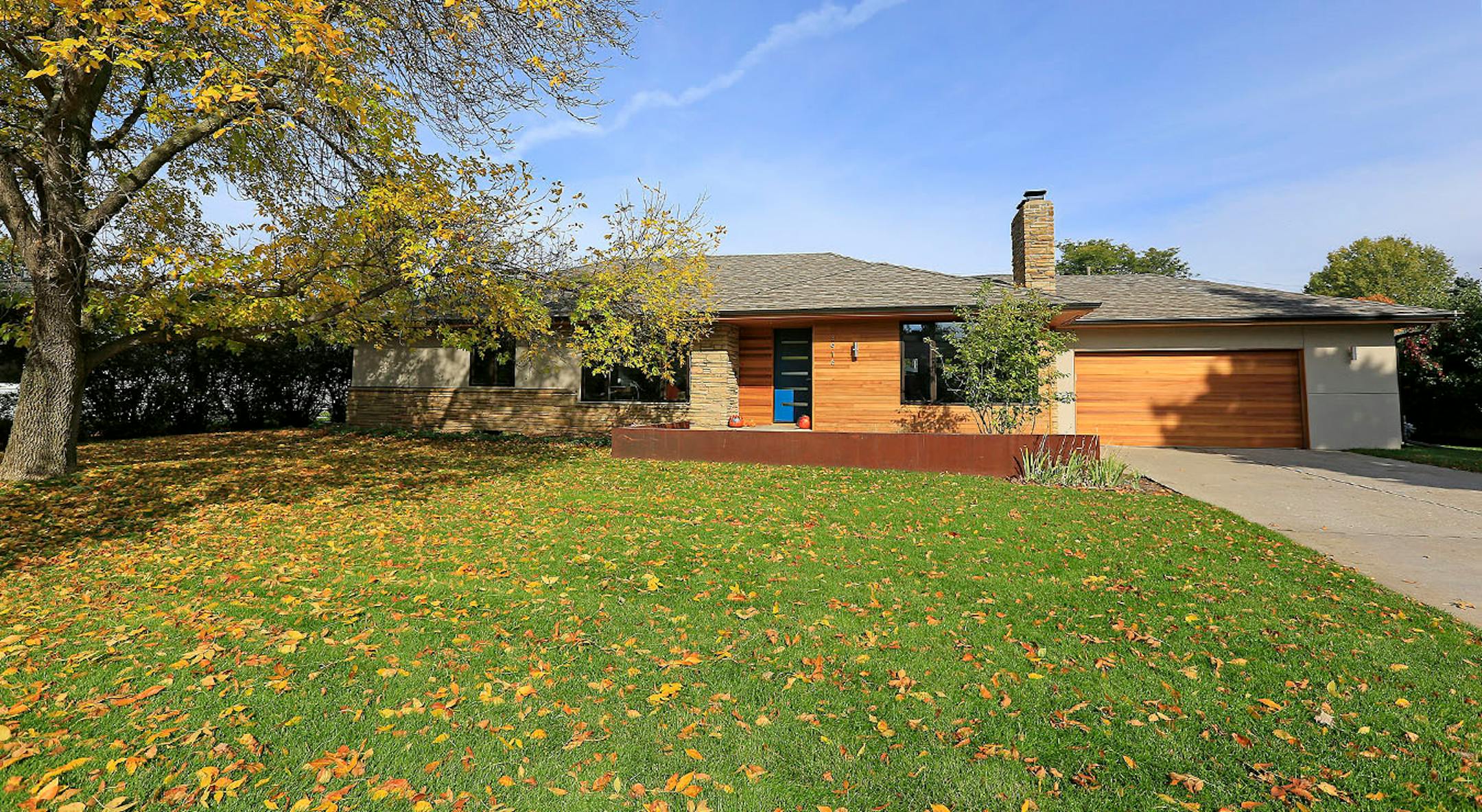 The rambler's refreshed exterior mixes cedar shiplap siding and stucco with the existing stone.