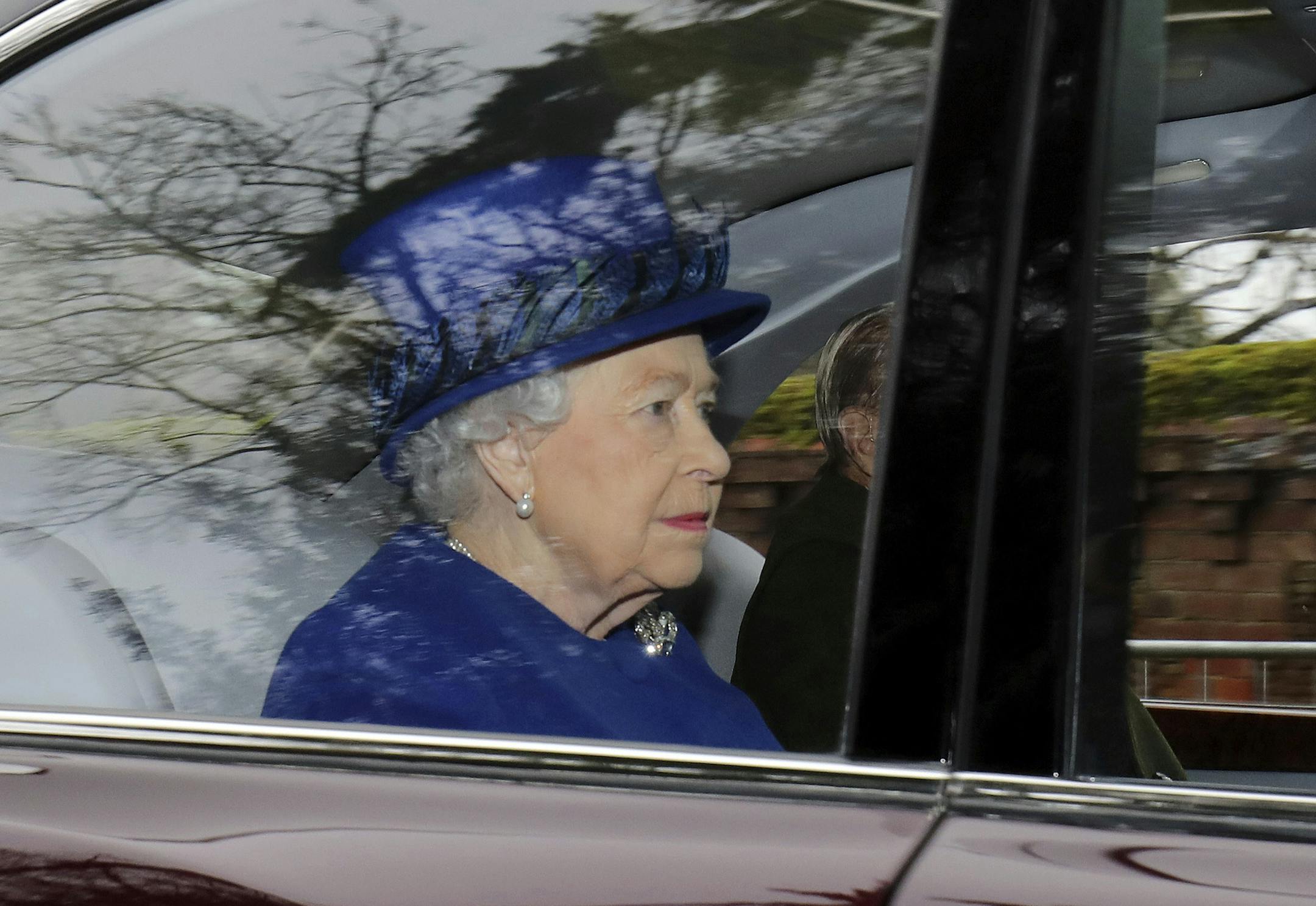 Britain's Queen Elizabeth II in a car with Prince Philip, arrives to attend the morning church service at St Mary Magdalene Church in Sandringham, England, Sunday Jan. 8, 2017. The 90-year-old British monarch was applauded by well-wishers as she arrived by car at St. Mary Magdalene Church in eastern England. It was her first public appearance in several weeks. (Chris Radburn/PA via AP)