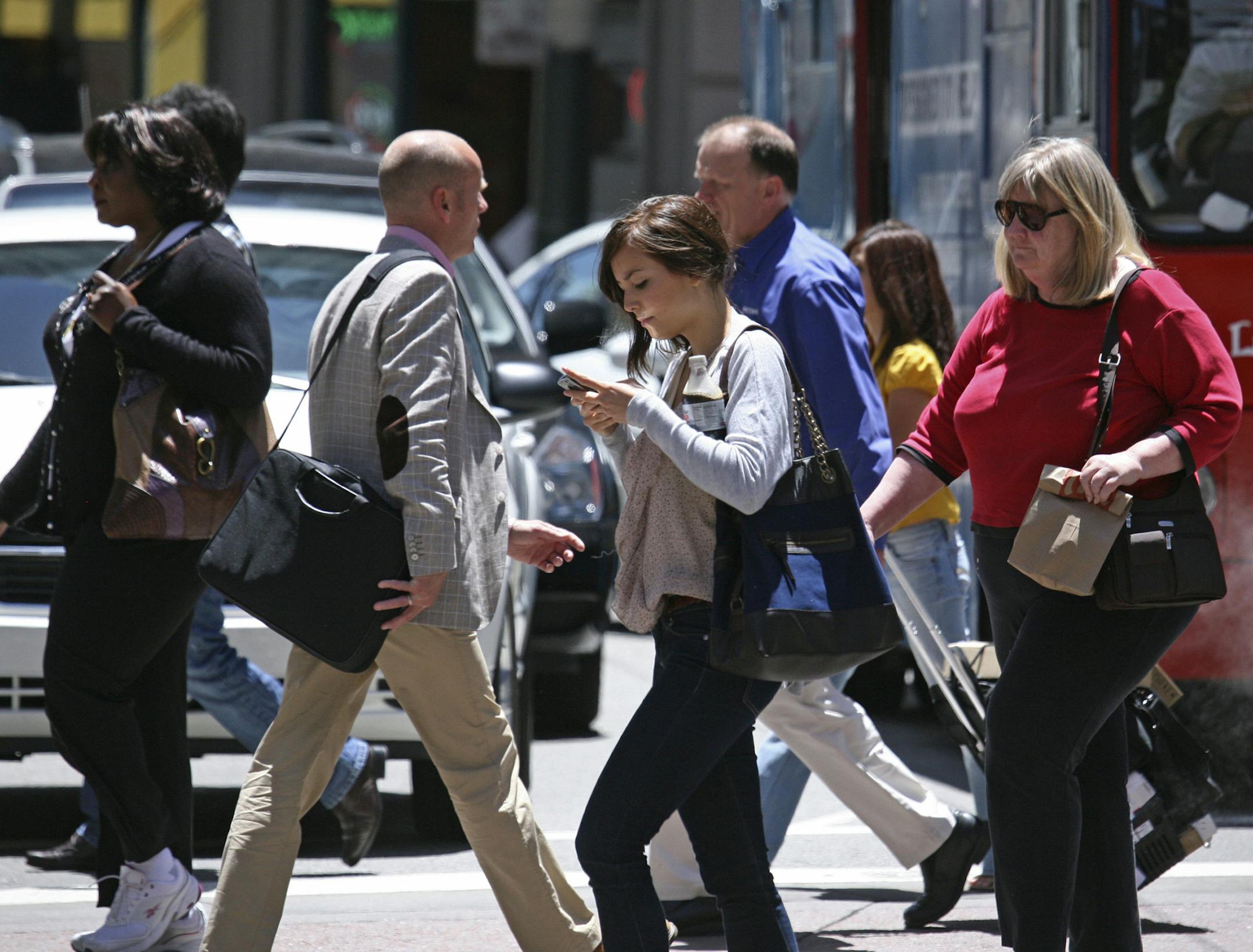 In this photo taken Wednesday, June, 29, 2010, a woman text messages while walking across the street in San Francisco. While using a cell phone while driving has triggered the most alarm bells and prompted laws in several states, experts say pedestrians are also suffering the consequences of mobile distraction tripping on curbs, walking into traffic, even stepping into manholes as they chat or type while walking. (AP Photo/Ben Margot)