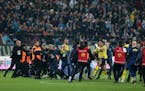 Fenerbahce's players clash with Trabzonspor supporters at the end of Turkish soccer match between Trabzonspor and Fenerbahce on Sunday night.