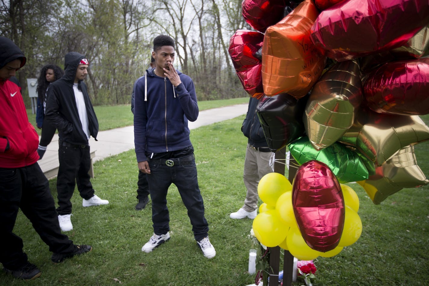 Friend Jordan Rhondes, 18, kissed his finger and placed it on a memorial at the site of the fatal shooting of 18-year-old Bobby Davion on Sunday. Photographed on Tuesday, April 19, 2016 in St. Paul, Minn.