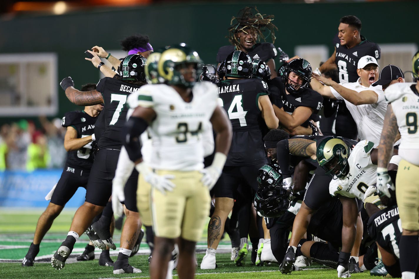 Hawaii rushes the field after place kicker Matthew Shipley (2) kicked a 51-yard field goal to defeat Colorado State 27-24 at the end of the second half of an NCAA college football game, Saturday, Nov. 25, 2023, in Honolulu. (AP Photo/Marco Garcia)