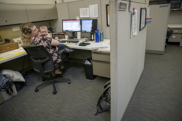 Amy Deutschman, worked at her cubicle with her infant daughter Noelle in hand, at an early education nonprofit Think Small, Wednesday, June 26, 2019 i