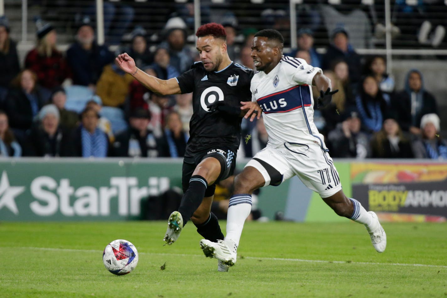 Vancouver forward Cristian Dájome is stopped on a run by Minnesota United defender D.J. Taylor in the first half Saturday at Allianz Field