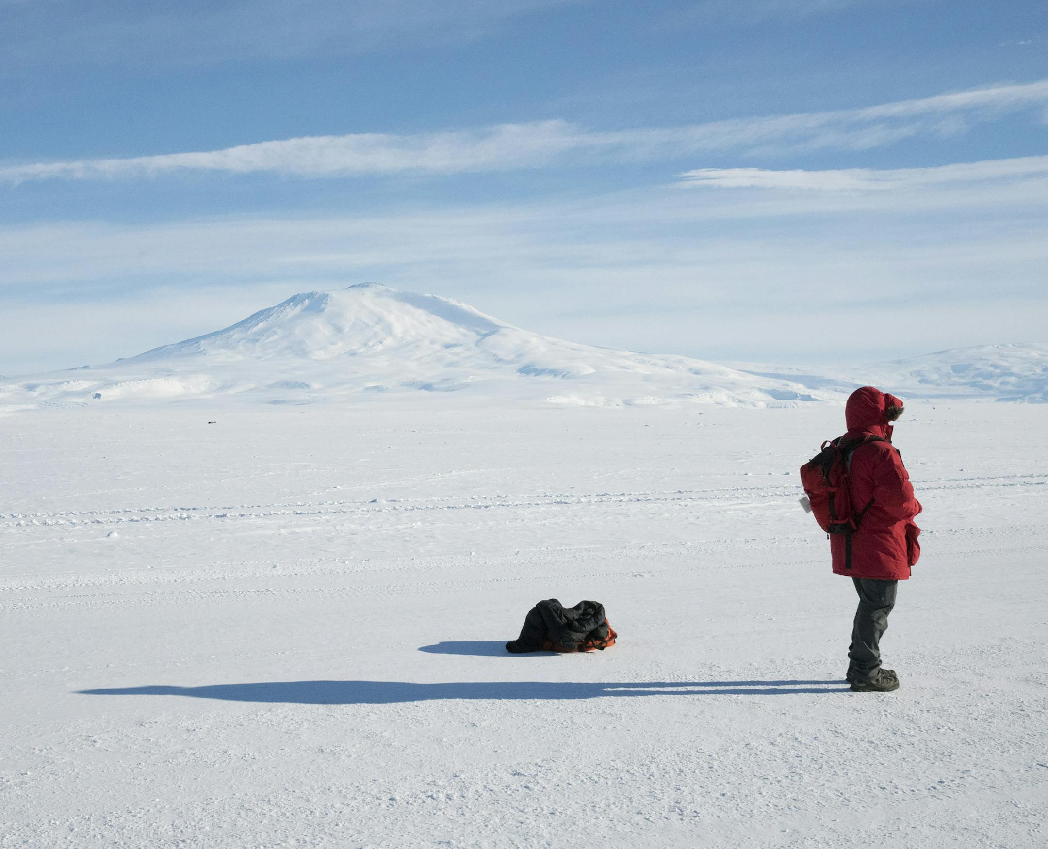 A McMurdo resident watches a NASA balloon launch while standing on the Ross Ice Shelf, with Mount Erebus in the distance, in Antarctica, November 2016. In an era when the Trump administration is seeking to slash federal spending, the fate of Antarctic research is an open question, as the aging, inefficient buildings at McMurdo need replacing. (Jonathan Corum/The New York Times) ORG XMIT: XNYT25