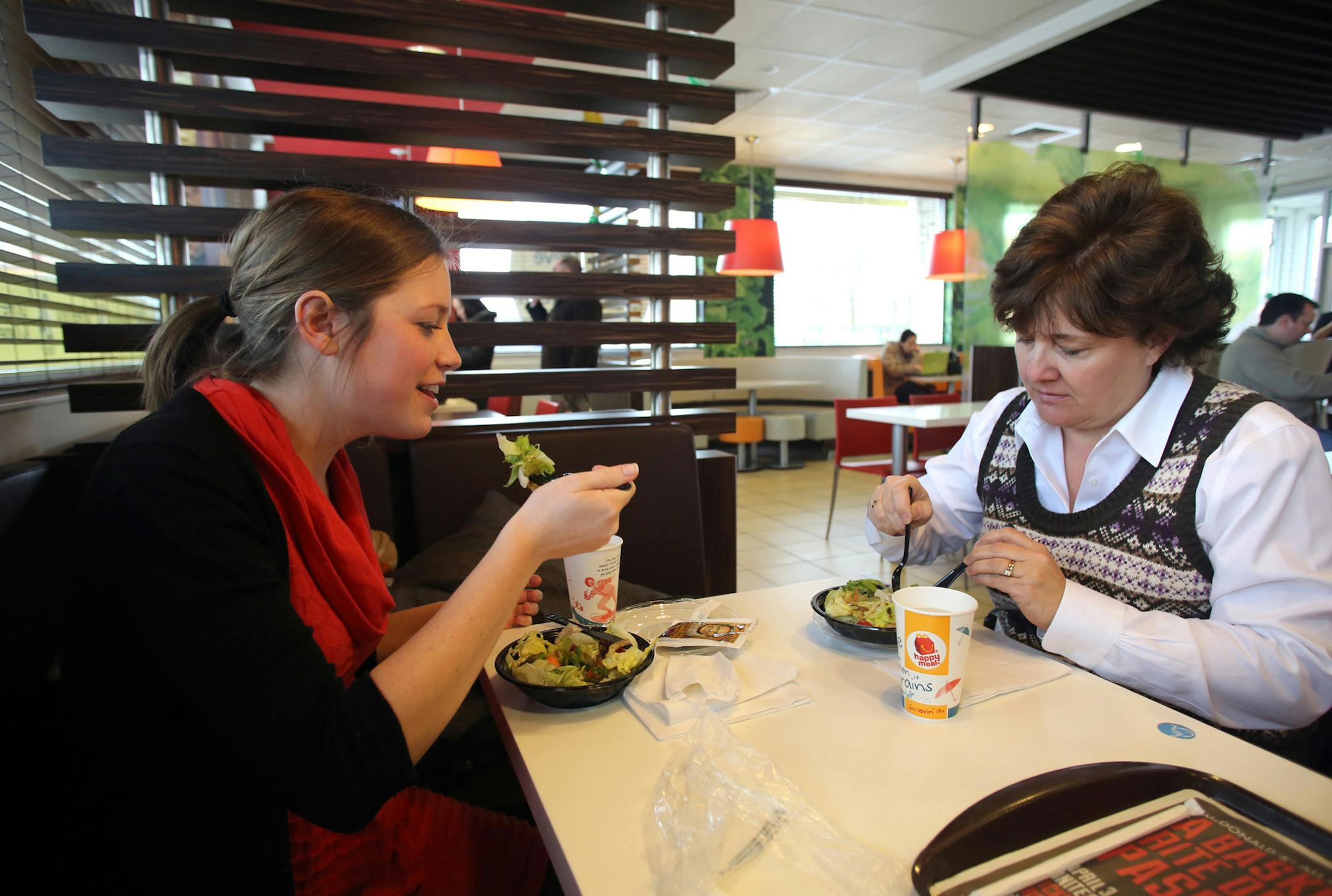 Aimie Zvosec, of Chicago, left, and Dina Phillip, of Naperville, dine on salads from McDonald's dollar menu, February 28, 2013 in Oak Brook, Illinois. McDonalds will be introducing new items for the dollar menu. (Chuck Berman/Chicago Tribune/MCT)
