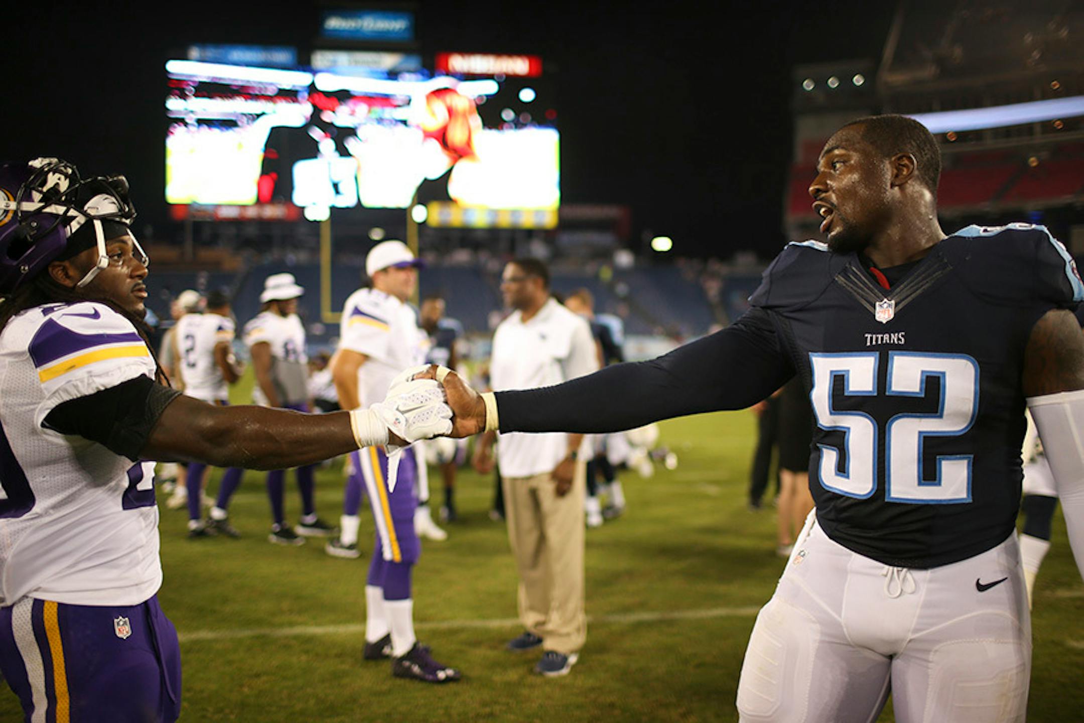 Vikings running back DuJuan Harris, left, and Tennessee Titans linebacker Jonathan Massaquoi said good bye at the end of the game Thursday night. They played college football together at Troy.