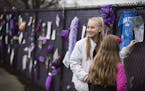 Anessa Reisinger, 13, of Excelsior puts a drawing on the "Prince4Ever" fence.