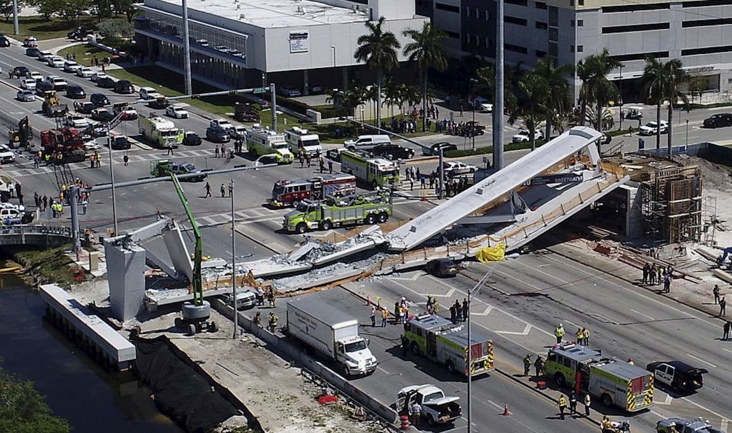 Emergency personnel respond after a brand-new pedestrian bridge collapsed onto a highway at Florida International University in Miami on Thursday, March 15, 2018. The pedestrian bridge collapsed onto the highway crushing multiple vehicles and killing several people.