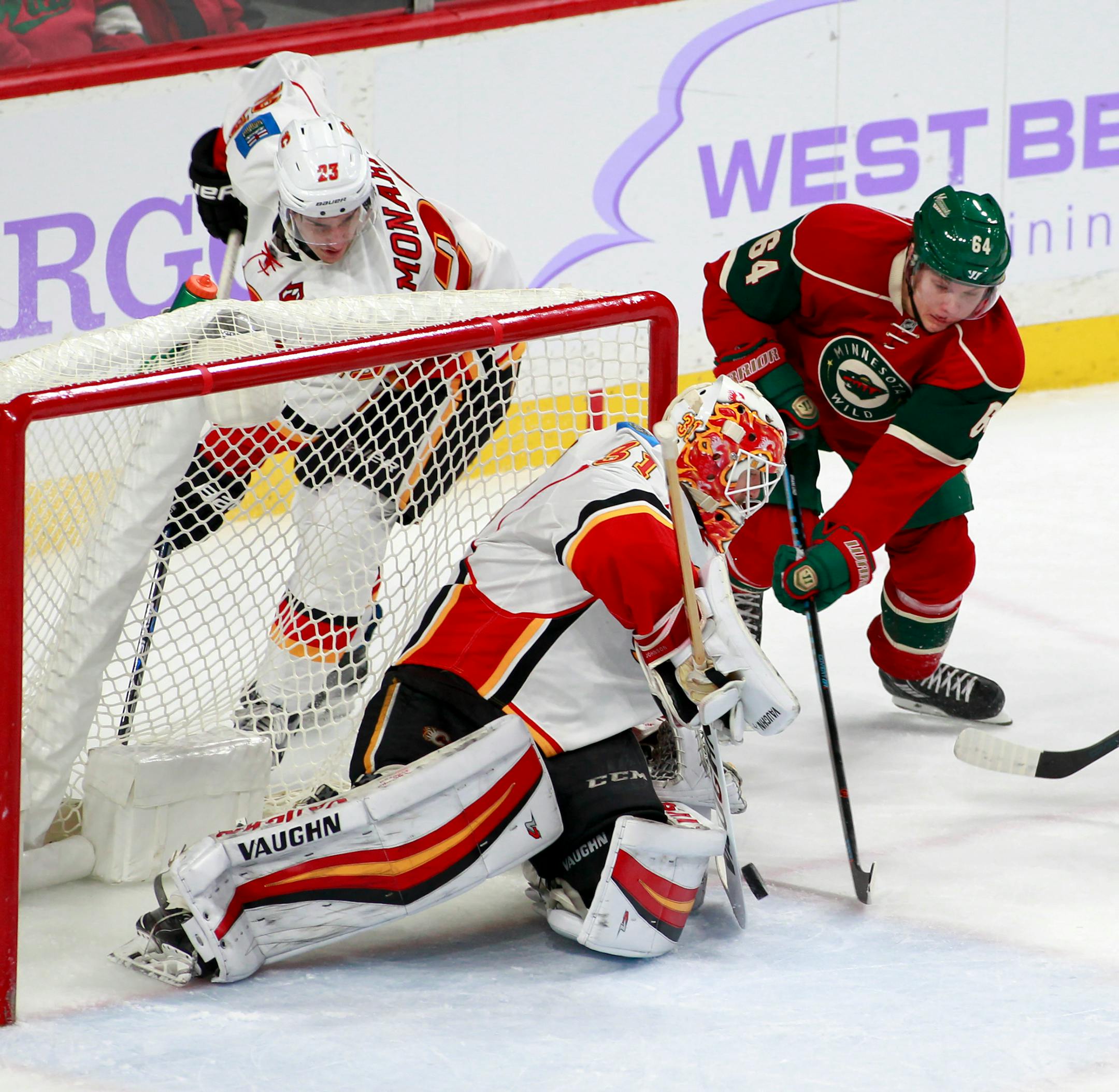 Minnesota Wild center Mikael Granlund (64), of Finland, tries to shoot the puck past Calgary Flames goalie Chad Johnson (31) as Calgary center Sean Monahan (23) watches during the third period of an NHL hockey game, Tuesday, Nov. 15, 2016, in St. Paul, Minn. Calgary won 1-0. (AP Photo/Paul Battaglia)