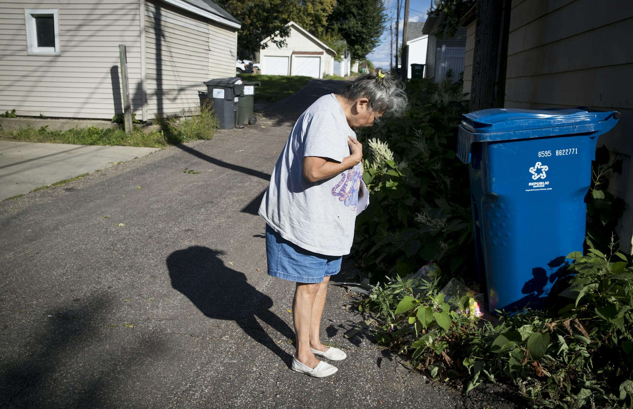A woman (who did not give her name but said she was a blood relative of the victim) did the sign of the cross after sprinkling medicinal herbs on the site where a teenage girl was killed in a robbery attempt in St. Paul, Minn. Photographed on Monday, September 26, 2016. ] RENEE JONES SCHNEIDER &#xef; renee.jones@startribune.com