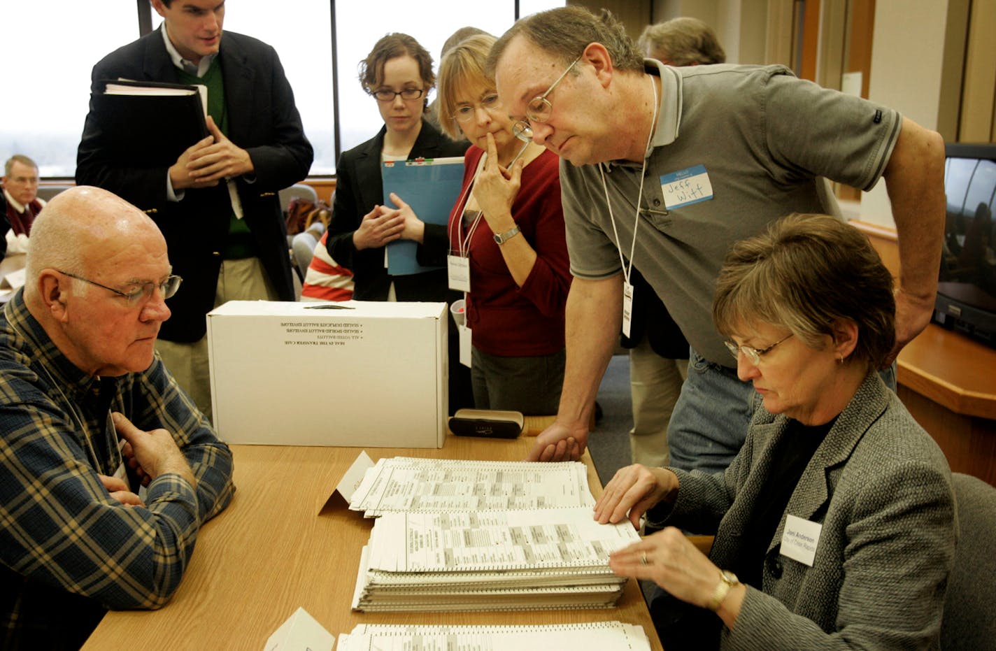 Election official Joni Anderson, right, begins the recount process in Anoka under the watchful eye of Lawrence Hosch, a Coleman observer from Andover, and Jeff Witt, standing right, a Franken observer from Spring Lake Park.