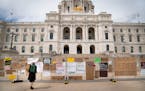 Julia Iwaszek looked Friday at signs posted on a gate surrounding the Minnesota State Capitol during a rally to commemorate Juneteenth in St. Paul.