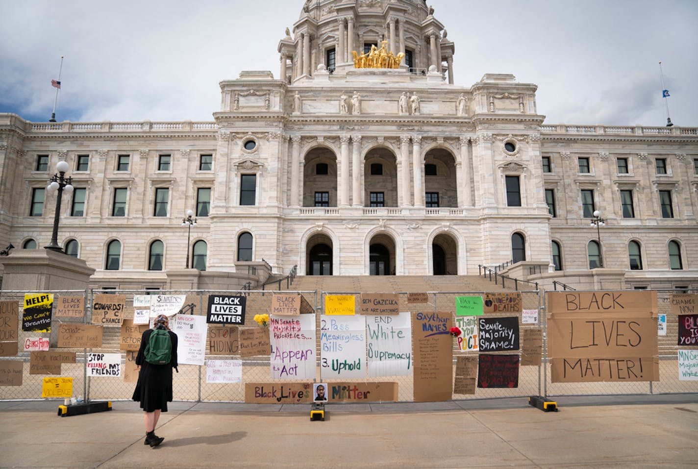 Julia Iwaszek looked Friday at signs posted on a gate surrounding the Minnesota State Capitol during a rally to commemorate Juneteenth in St. Paul.