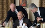 FILE - In this Friday, Nov. 11, 2011 file photo, businessman Yevgeny Prigozhin, left, serves food to Russian Prime Minister Vladimir Putin, center, du