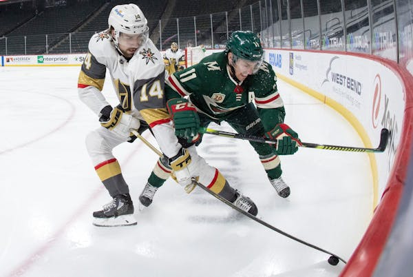 Nicolas Hague (14) of the Las Vegas Golden Knights and Zach Parise (11) of the Minnesota Wild fought for the puck in the first period.