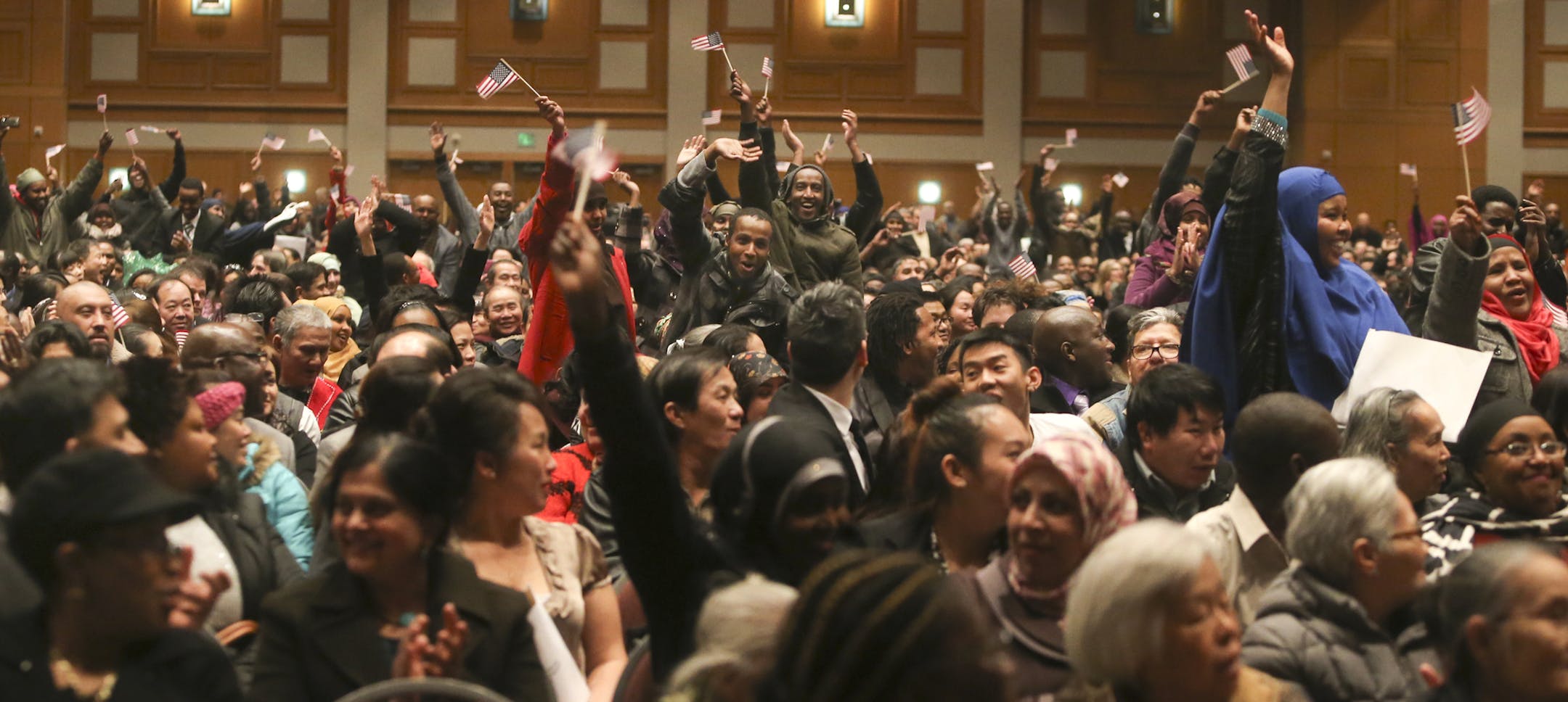 As the country of Somalia was read during a Naturalization ceremony for 1,501 immigrants comprising hundreds of countries, some of those who originated from Somalia, stood up to be acknowleged prior to the ceremony at the Minneapolis Convention Center, Tuesday, Jan. 21, 2014, in Minneapolis, MN.](DAVID JOLES/STARTRIBUNE) djoles@startribune.com A Naturalization ceremony for 1,501 immigrants comprising hundreds of countries was held at the Minneapolis Convention Center. Following the ceremony, 85