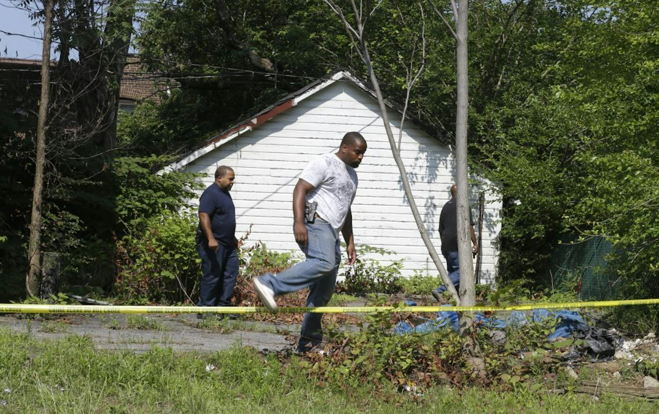 East Cleveland police search Sunday, July 21, 2013, near where three bodies were recently found, in East Cleveland, Ohio.